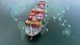 Aerial view of a cargo ship over a world map, image by APchanel/Adobe Stock