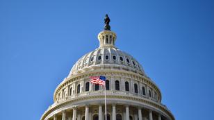 The top of the U.S. Capitol Building with an American flag in front of it, photo by Perry Spring/Getty Images