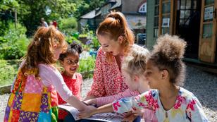 A teacher and her pupils doing storytime outdoors in the schoolyard, photo by SolStock/Getty Images