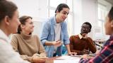 Group of students sitting around a table having a discussion, photo by Seventyfour/Adobe Stock