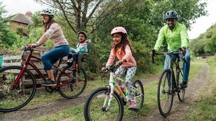 Multi-racial family riding their bikes around a public park, photo by SolStock/Getty Images