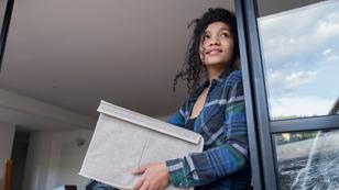 Young Afro-Latina woman holding a fabric box and looking out a window, photo by Mario Arango/Getty Images