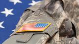 A U.S. Army uniform over an American flag, photo by Serhej Calka/Getty Images