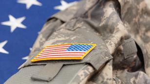 A U.S. Army uniform over an American flag, photo by Serhej Calka/Getty Images