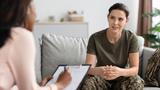 A soldier sits on a therapist's couch, photo by Prostock-studio/Adobe