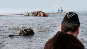 A Ukrainian Navy officer looks at the scuttled decommissioned Russian vessel Ochakov from the Black Sea shore outside the town of Myrnyi, western Crimea, Ukraine, Thursday, March 6, 2014, photo by Darko Vojinovic/AP
