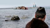 A Ukrainian Navy officer looks at the scuttled decommissioned Russian vessel Ochakov from the Black Sea shore outside the town of Myrnyi, western Crimea, Ukraine, Thursday, March 6, 2014, photo by Darko Vojinovic/AP