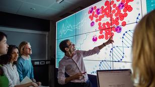An instructor teaching a biology lesson and pointing to a chart, photo by SolStock/Getty Images