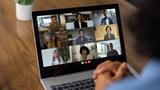 Laptop displaying a grid of people in a virtual meeting, photo by Hispanolistic/Getty Images