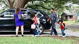 Family with two children getting in the car outside their house, photo by Anchiy/Getty Images