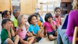 Diverse preschool children in a classroom for story time, photo by FatCamera/Getty Images