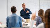 Student raising hand in classroom at the high school