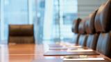Closeup of a table and chairs in a modern boardroom, photo by IPGGutenbergUKLtd/Getty Images