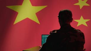 A man in a military uniform using a laptop in front of a projected Chinese flag, photo by Dragos Condrea/Getty Images