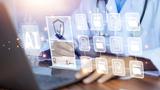 Doctor using a laptop with superimposed AI images of files above the keyboard, photo by The best photo for all/Getty Images