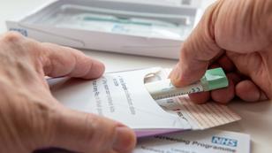 Close up of a person putting a collected bowel cancer sample in an envelope to be sent off for testing, photo by Ming/Adobe Stock.