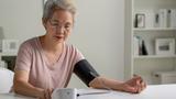 Senior woman measuring her blood pressure at home, photo by amenic181/Adobe Stock