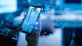 Close up of a hand holding a smartphone displaying a call with a doctor, photo by greenbutterfly/Adobe Stock