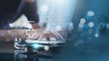 Hand on a laptop overlaid with the icons of a virtual health interface, photo by tippapatt/Adobe Stock