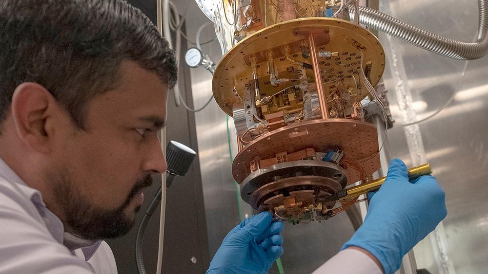 A scientist from the Laboratory for Physical Sciences loading a high quality factor superconductor resonator on the measurement state of an adiabatic demagnetization refrigerator that can reach temperatures as low as 50 mK, photo by Laboratory for Physical Sciences/Quantum Image Gallery.