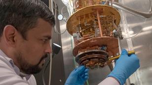 A scientist from the Laboratory for Physical Sciences loading a high quality factor superconductor resonator on the measurement state of an adiabatic demagnetization refrigerator that can reach temperatures as low as 50 mK, photo by Laboratory for Physical Sciences/Quantum Image Gallery.
