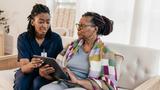 Home health care aide assisting an older woman using a digital tablet, photo by kate_sept2004/Getty Image