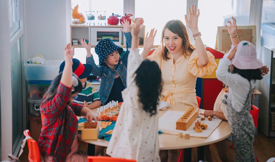 An Asian woman teaches pre-K students in a classroom, photo by Edwin Tan/Getty Images