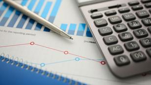 A calculator on top of a notebook displaying bar graphs, photo by H_Ko, Adobe stock